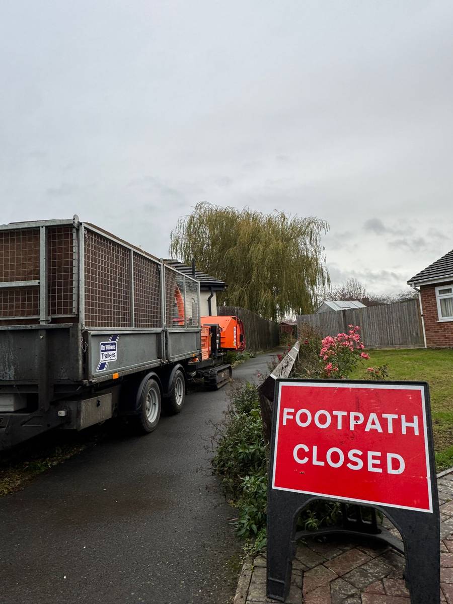 Footpath closed sign with work truck and chipper